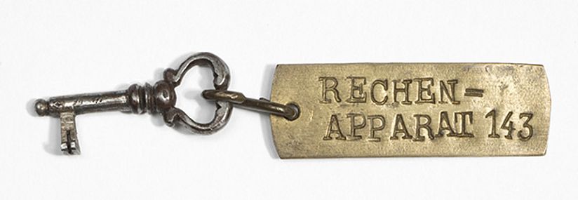 Schlüssel mit kleinem Anhänger "Rechenapparat 143".