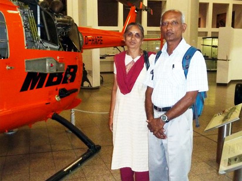 Muralidhara and his wife from India in front of helicopter in the aeronautics exhibition.