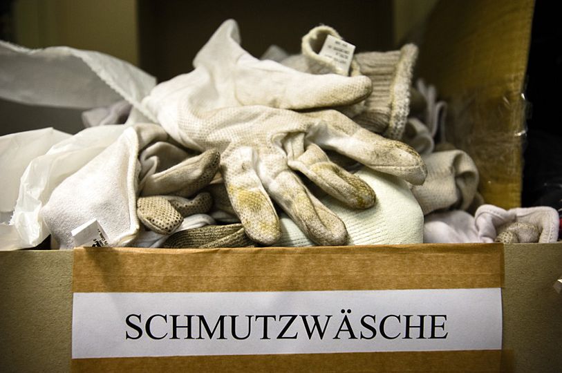Schmutzwäsche: eine Kiste gebrauchter, weißer Handschuhe.