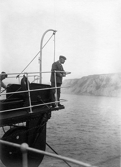Schwarz-weiß Fotografie zeigt den Leiter Tiefseekabelverlegung am Bug des Schiffes.
