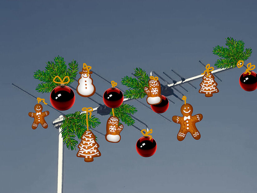 Amateurfunk-Antenne weihnachtlich geschmückt mit Lebkuchen-Figuren, roten Christbaumkugeln und ein paar Tannenzweigen.