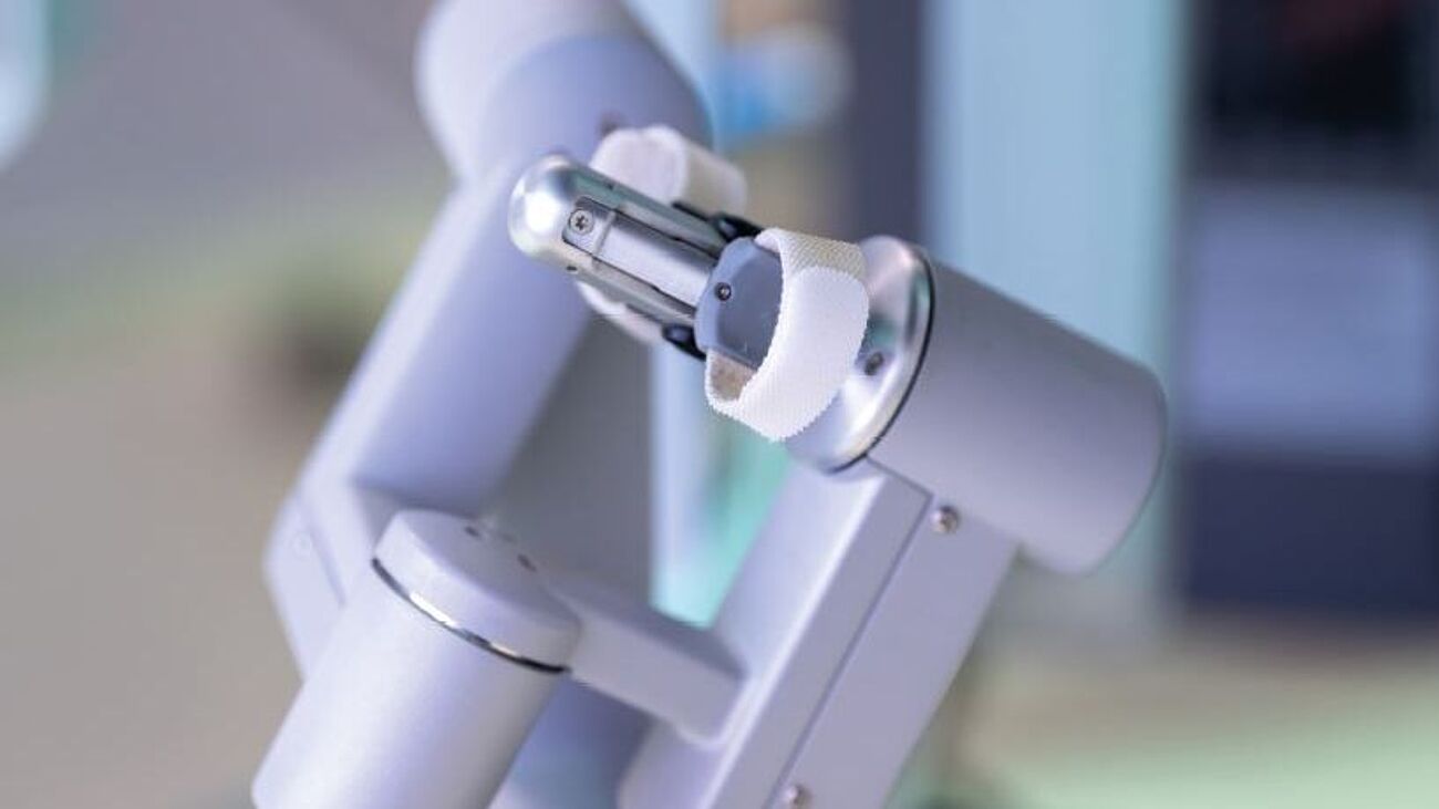 Nahaufnahme eines grauen, gewinkelten Apparates, der an einer Seite zangenartig zusammenläuft.