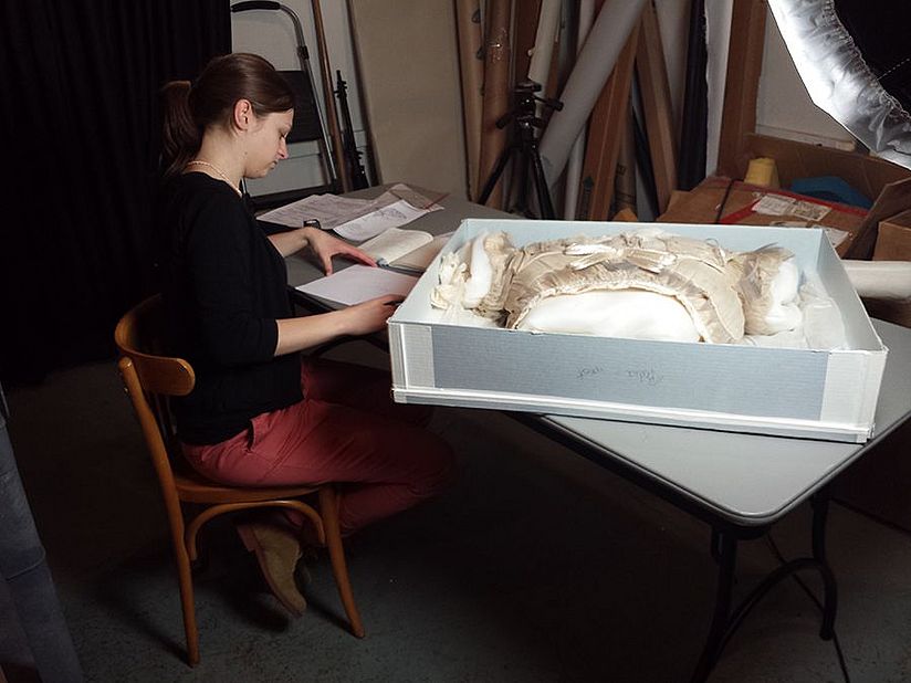 Charlotte Holzer bei der Untersuchung des Oberteils des Glasfaserkleids.