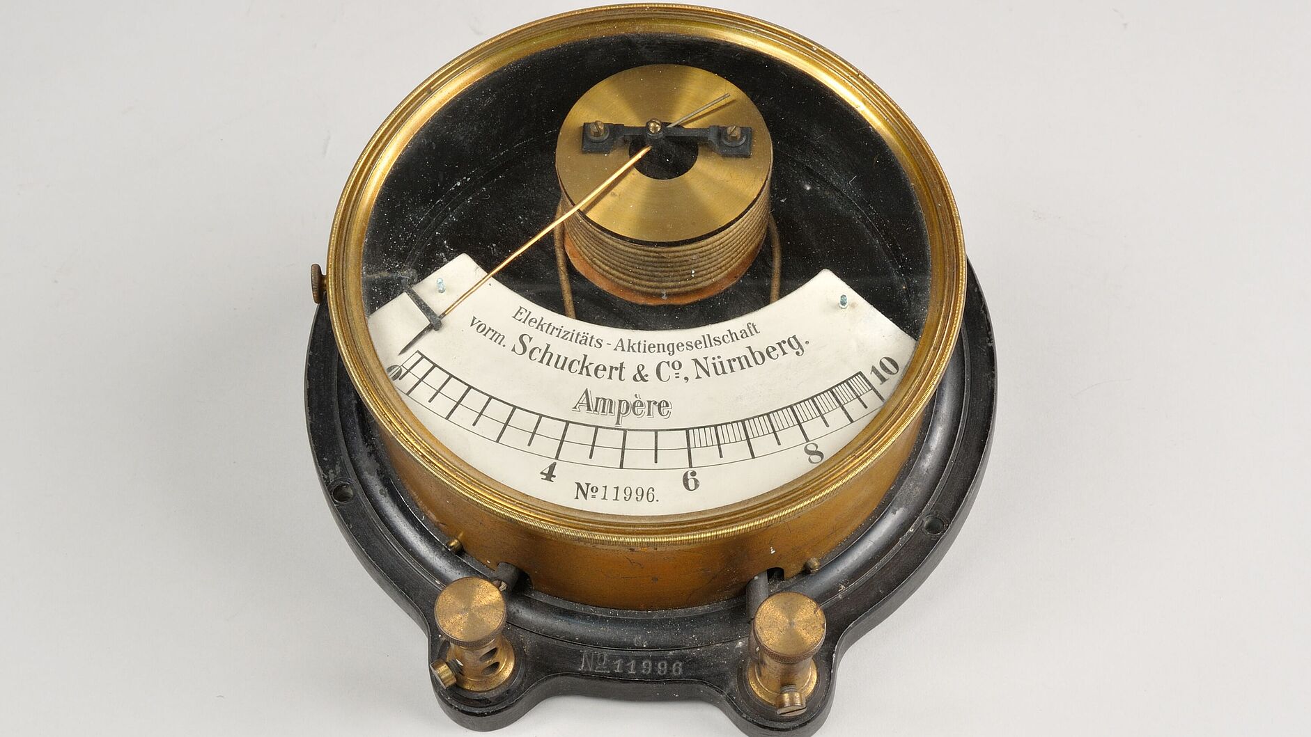 Farbfotografie von Amperemeter. Messingfarben und Schwarz. Anzeige in weiß von 0 bis 10 Ampere mit Zeiger.