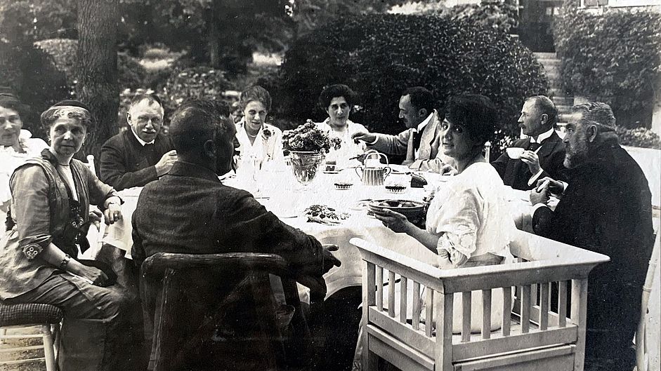 Schwarzweiß-Fotoaufnahme: Oskar von Miller mit Emanuel von Seidl aa Kaffetafel, 1915