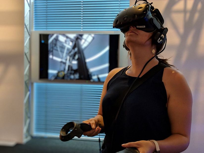 Frau mit VR-Brille und Controllerim VRlab des Deutschen Museums.