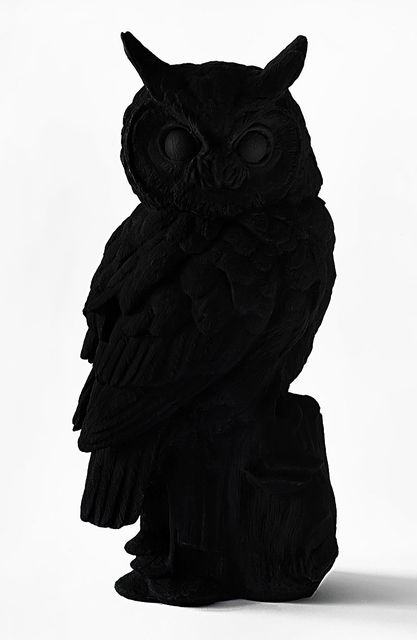 Schwarz bemalte Eulenfigur.