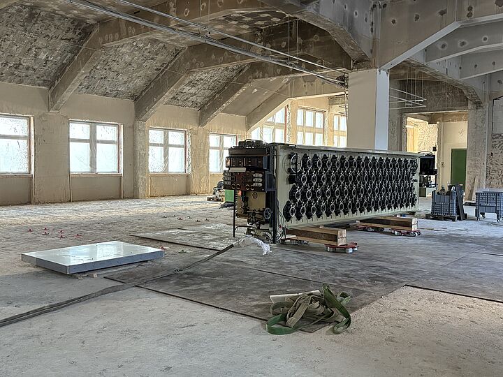 Der Gezeitenrechner steht auf Stahlplatten und einer Unterkonstruktion aus Holz und Metall auf der Baustelle.