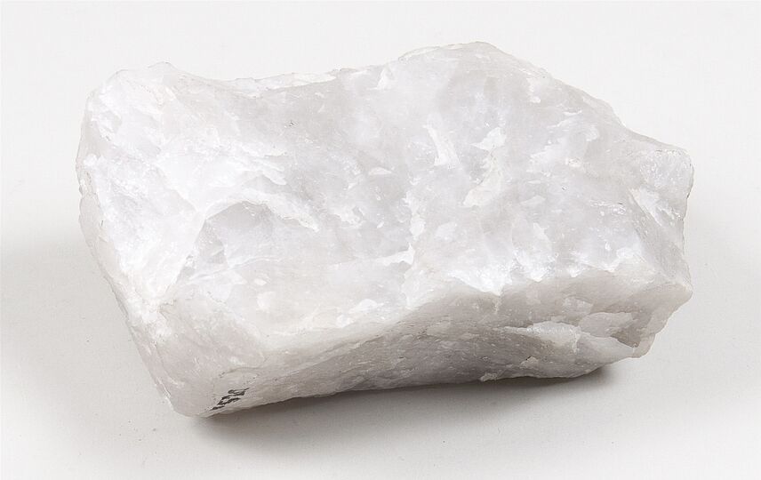 Weißgraue Quarzprobe mit kristalliner, glasartig glänzender Oberfläche.