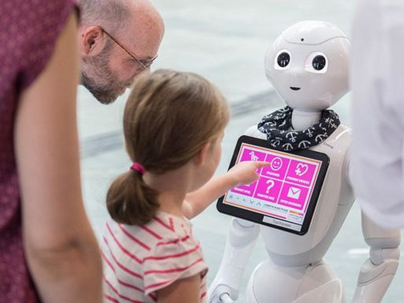 Besucher mit Roboter Pepper.