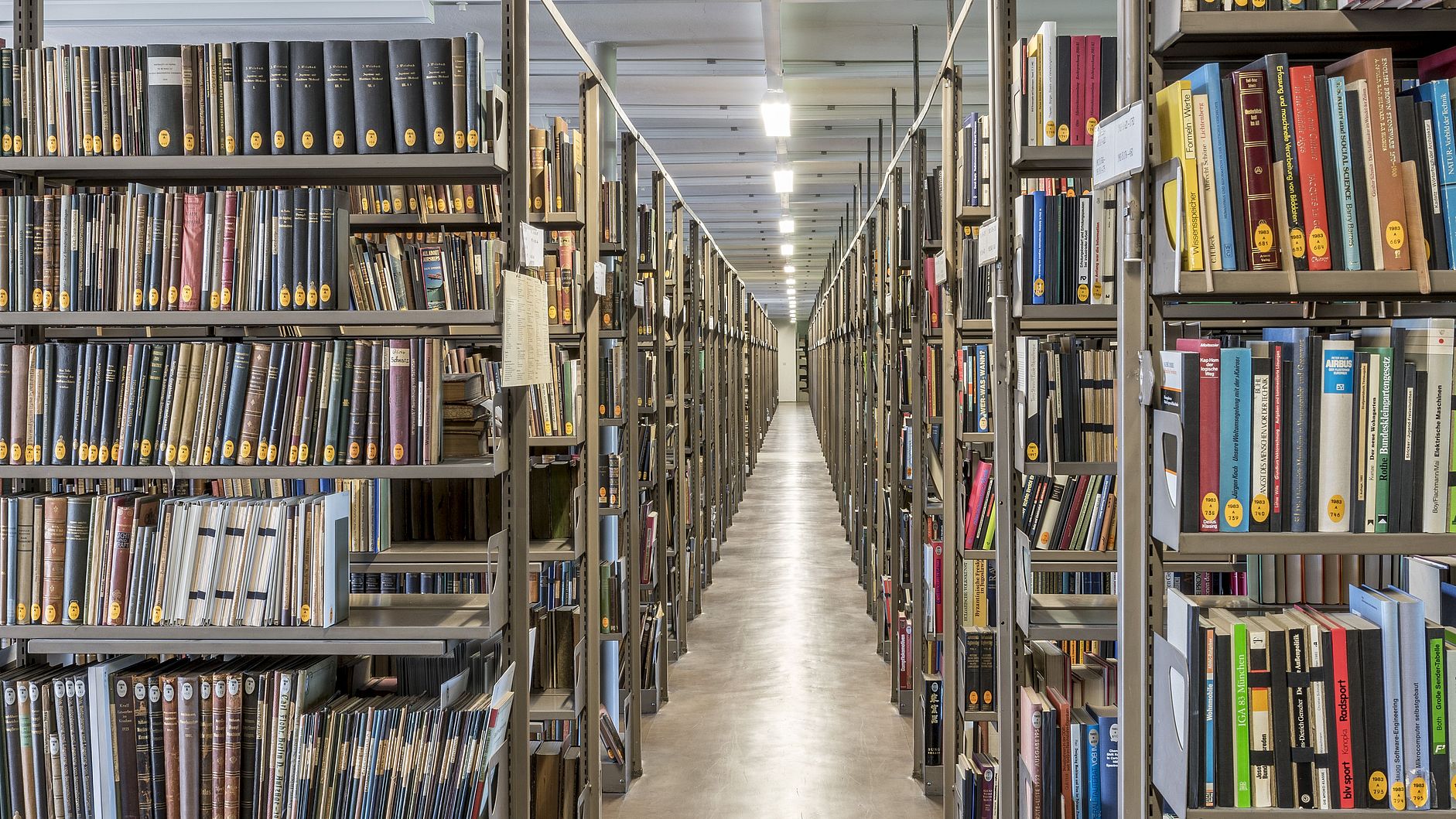 Ein Gang zwischen den gefüllten Bücherregalen des Bibliotheksmagazins.