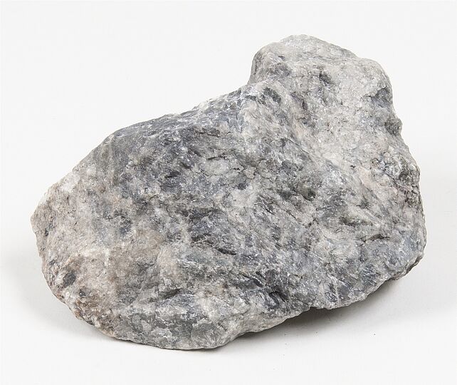 Magnetit-Gestein: grauschwarzes Mineral mit kristalliner Struktur auf weißem Hintergrund.