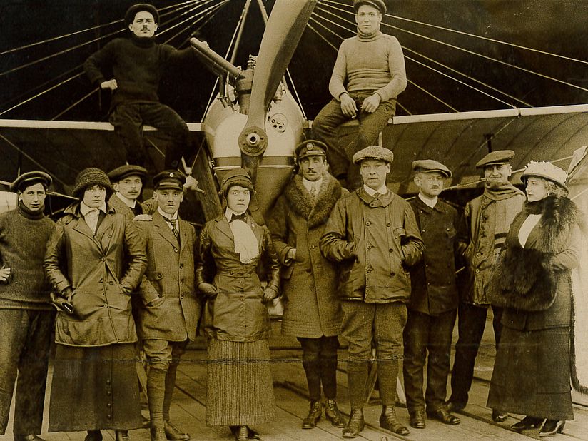 Melli Beese im Kreise ihrer FlugschülerInnen und Fluglehrer, vor der Schulmaschine „Melli-Beese-Taube“.