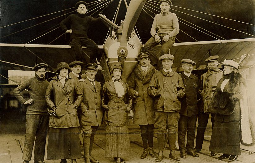 Melli Beese im Kreise ihrer FlugschülerInnen und Fluglehrer, vor der Schulmaschine „Melli-Beese-Taube“.