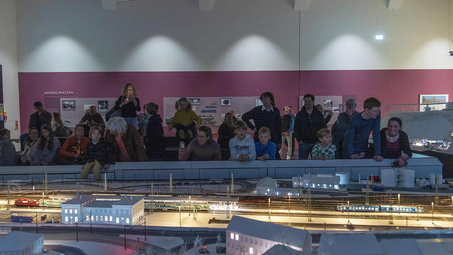 Besucherinnen und Besucher schauen gespannt die Vorführung der Modellbahnanlage an.