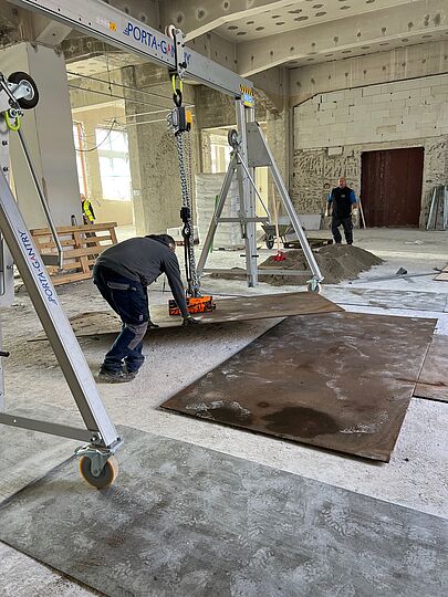 Bauarbeiter bringen Stahlplatten auf dem Boden an. 