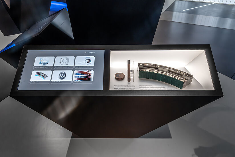 Aufnahme der Medienstation zur Erklärung des MRT zusammen mit den ausgestellten Exponaten: ein Supraleitung Rohling und ein Segment einer Gradientenspule