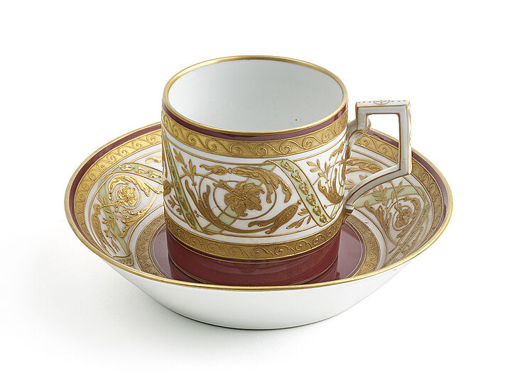 Edle Kaffeetasse in rot und gold mit Untertasse.