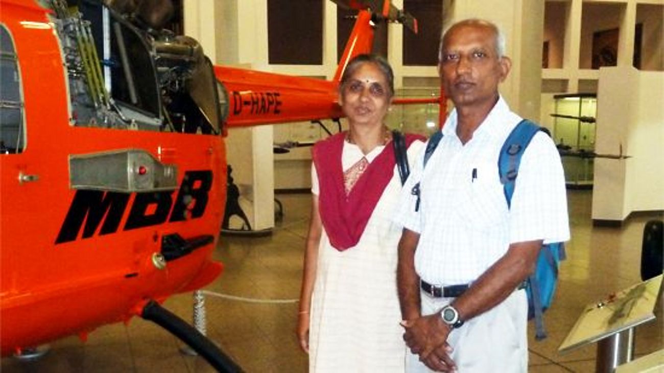 Muralidhara and his wife from India in front of helicopter in the aeronautics exhibition.