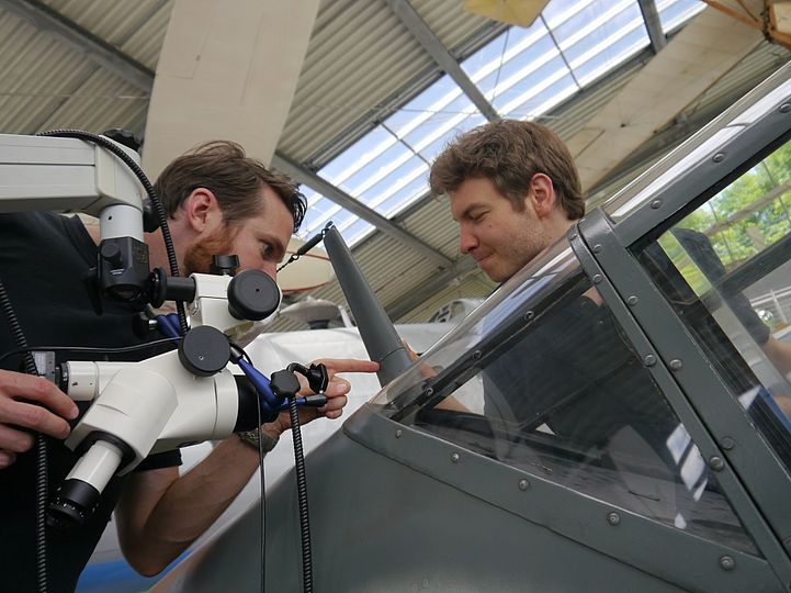 Alexander Grillparzer und Andreas Hempfer heben das Stereomikroskop an den Antennenmast.
