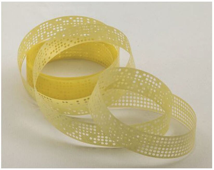 Gelber Lochstreifen, lose in mehreren Spiral gewickelt.