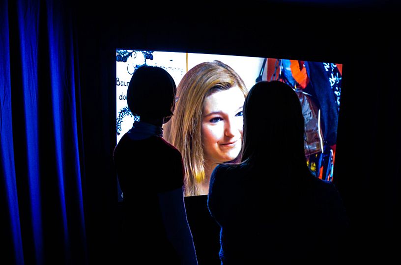 Besucherinnen schauen einen Film in der Sonderausstellung @Home.