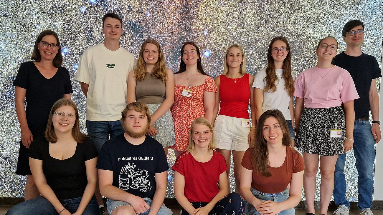 Gruppenfoto von 12 Personen in zwei Reihen, vordere Reihe kiend.
