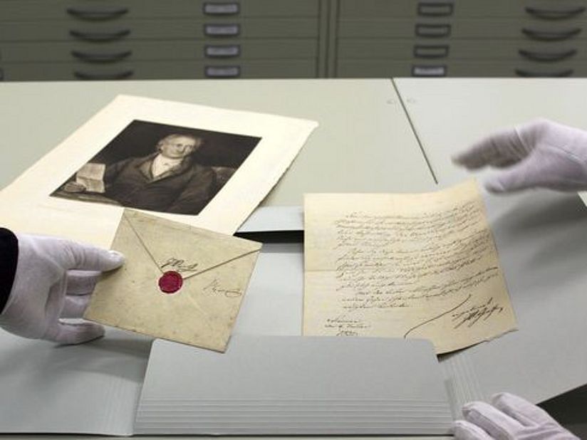 Hände mit Handschuhen halten Dokumente.