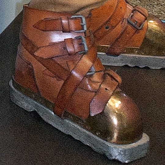 Detailfoto zeigt alte Schuhe aus Leder und Metall.