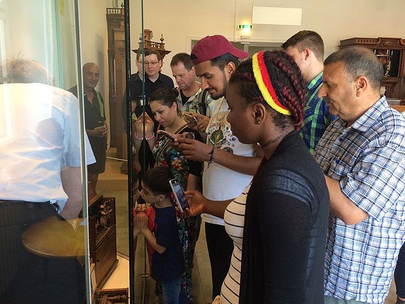 Besucher*innen vor einer Vitrine in der Ausstellung Musikinstrumente.