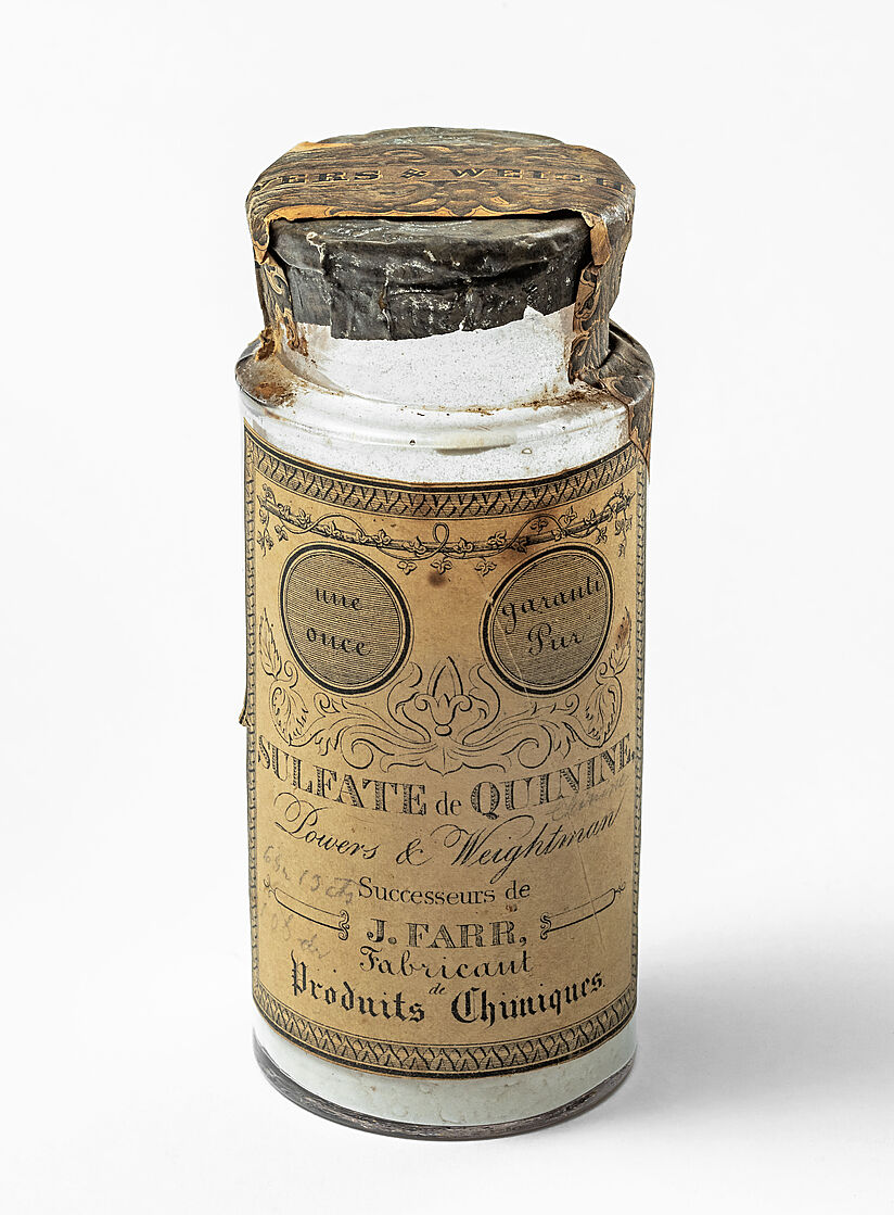 Gläsernes Apothekerfläschchen mit Papierstreifen versiegelt. Hauptschriftzug auf vergilbtem Label: Sulfate de Quinine.