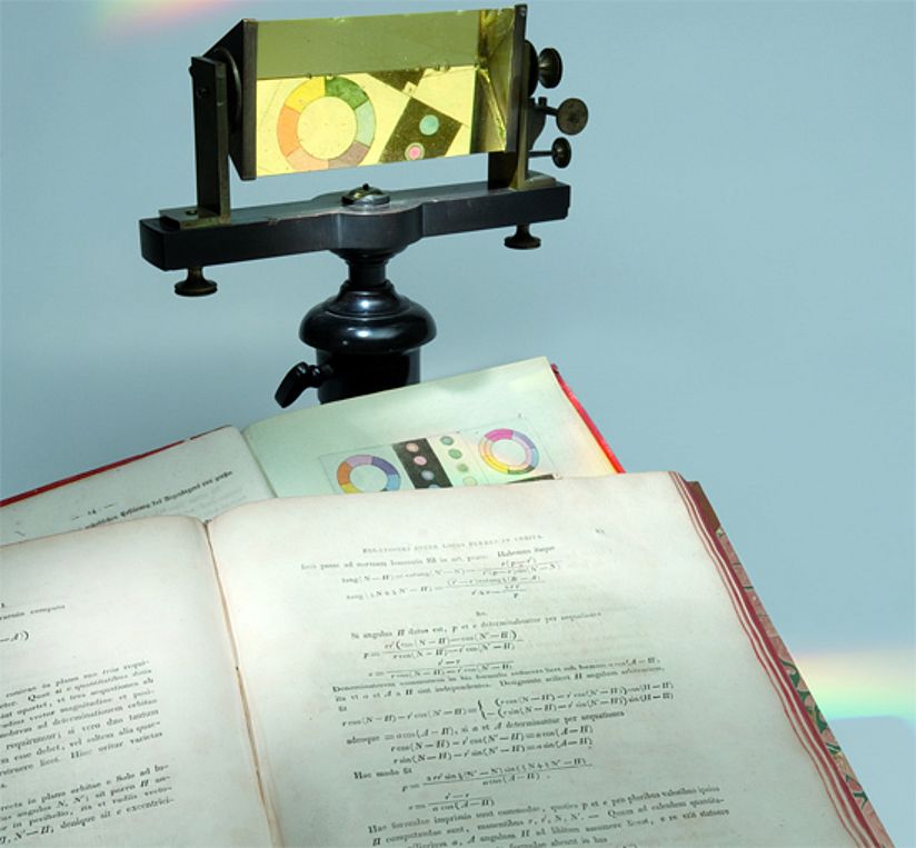 Johann Wolfgang von Goethe, Zur Farbenlehre. Tübingen 1810, Carl Friedrich Gauß: Theoria Motus Corporum Coelestium In Sectionibus Conicis Solem Ambientium. Hamburg 1809 und ein Flintglasprisma von Joseph von Fraunhofer auf einem Holzstativ, frühes 19. Jh. 