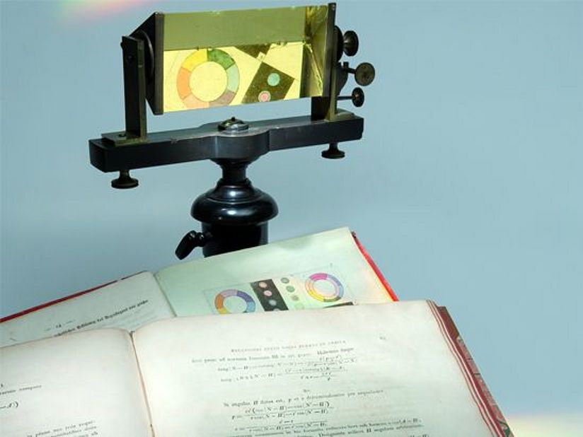 Johann Wolfgang von Goethe, Zur Farbenlehre. Tübingen 1810, Carl Friedrich Gauß: Theoria Motus Corporum Coelestium In Sectionibus Conicis Solem Ambientium. Hamburg 1809 und ein Flintglasprisma von Joseph von Fraunhofer auf einem Holzstativ, frühes 19. Jh.