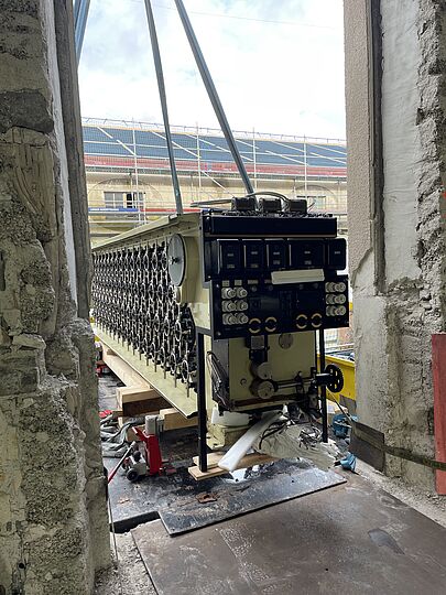 Blick aus dem zweiten Stock der Baustelle durch das geöffnete Fenster auf den Rechner.