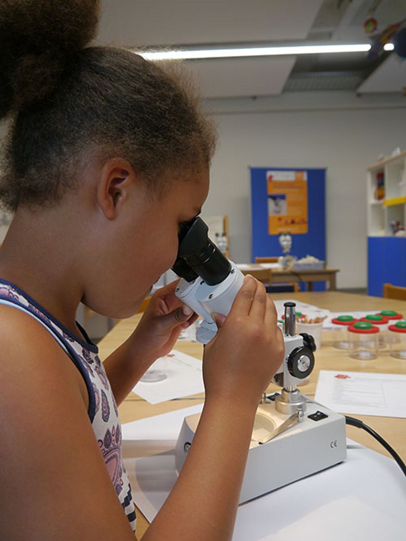 Mädchen mit Mikroskop.
