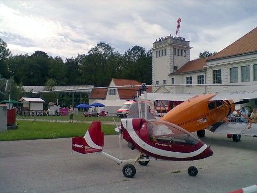 Im Vordergrund ein einsitziger motorisierter Tragschrauber. Dahinter ein Doppeldecker WACO.