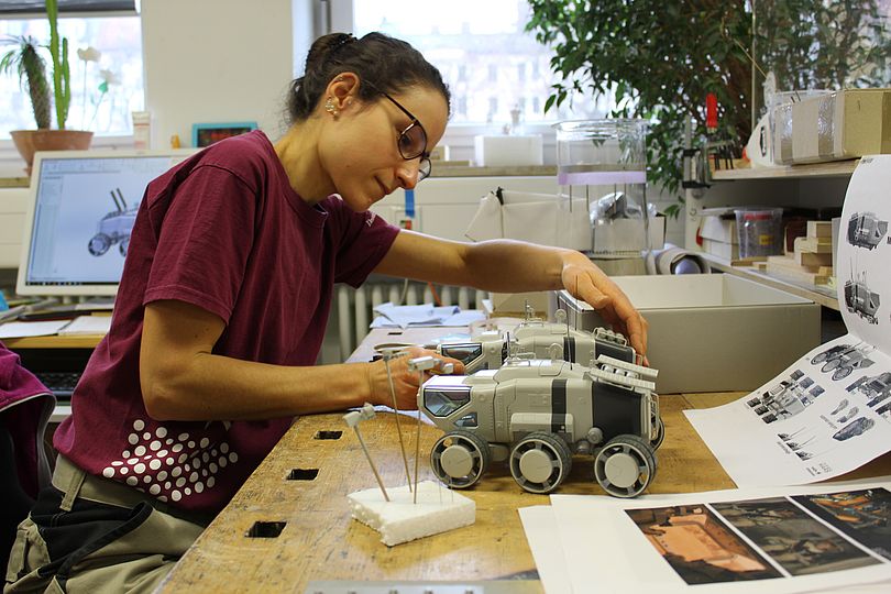 Modellbauerin arbeitet an dem Modell des Mars-Rovers.