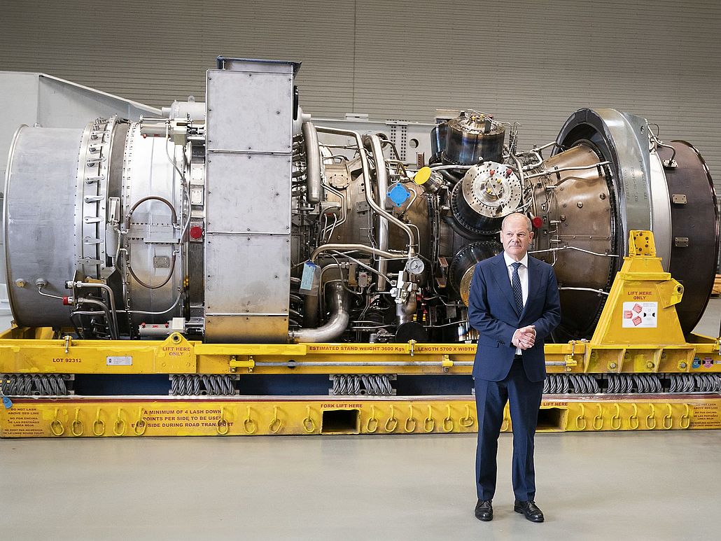 Bundeskanzler Olaf Scholz vor einer Gasturbine.