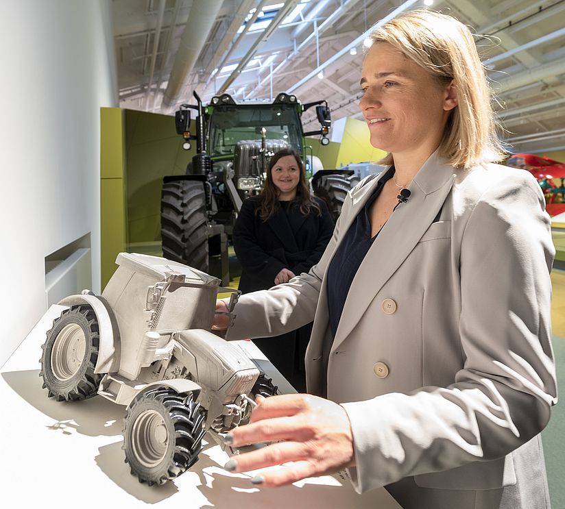 Verena Bentele tastet ein Tastmodell eines Traktors ab.