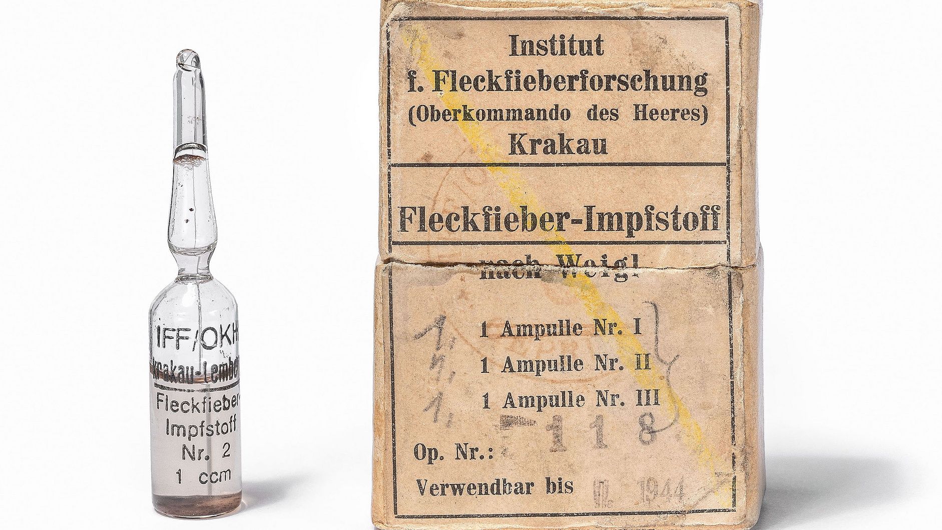 Eine Ampulle und eine Papierpackung. 