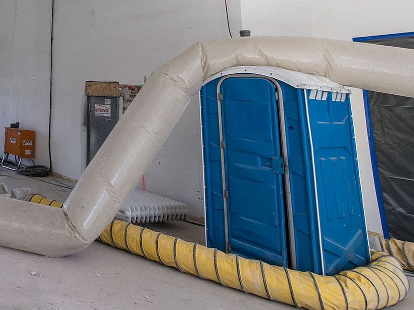 Dixieklo und Schläuche auf der Baustelle.