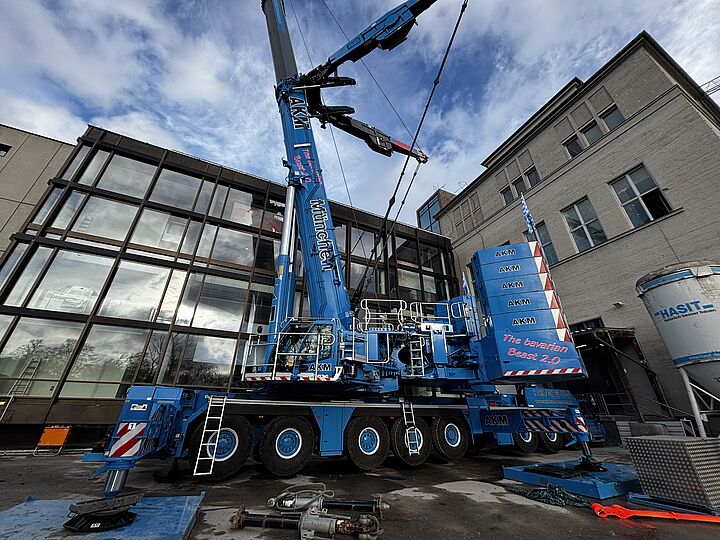 Ein blauer Autokran steht vor der östlichen Seite der Luft- und Raumfahrthalle.