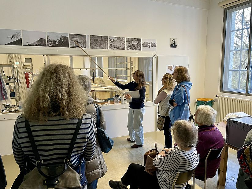 Charlotte Holzer zeigt den Teilnehmerinnen, wie der Normal-Segelapparat während der Anfänge des Museums ausgestellt wurde.