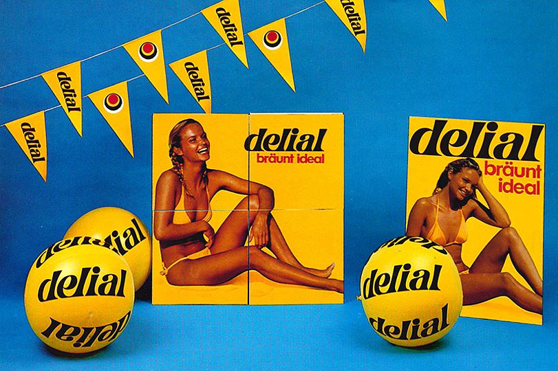 Werbeplakate von delial zeigt eine lachende, gebräunte Frau im Bikini. Slogan: "delial bräunt ideal".