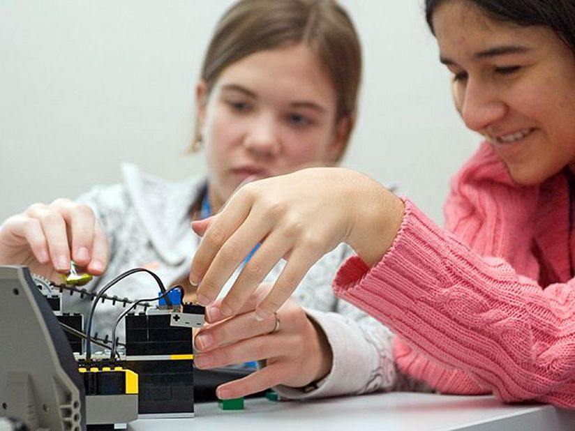 Mädchen experimentieren mit einem Roboter