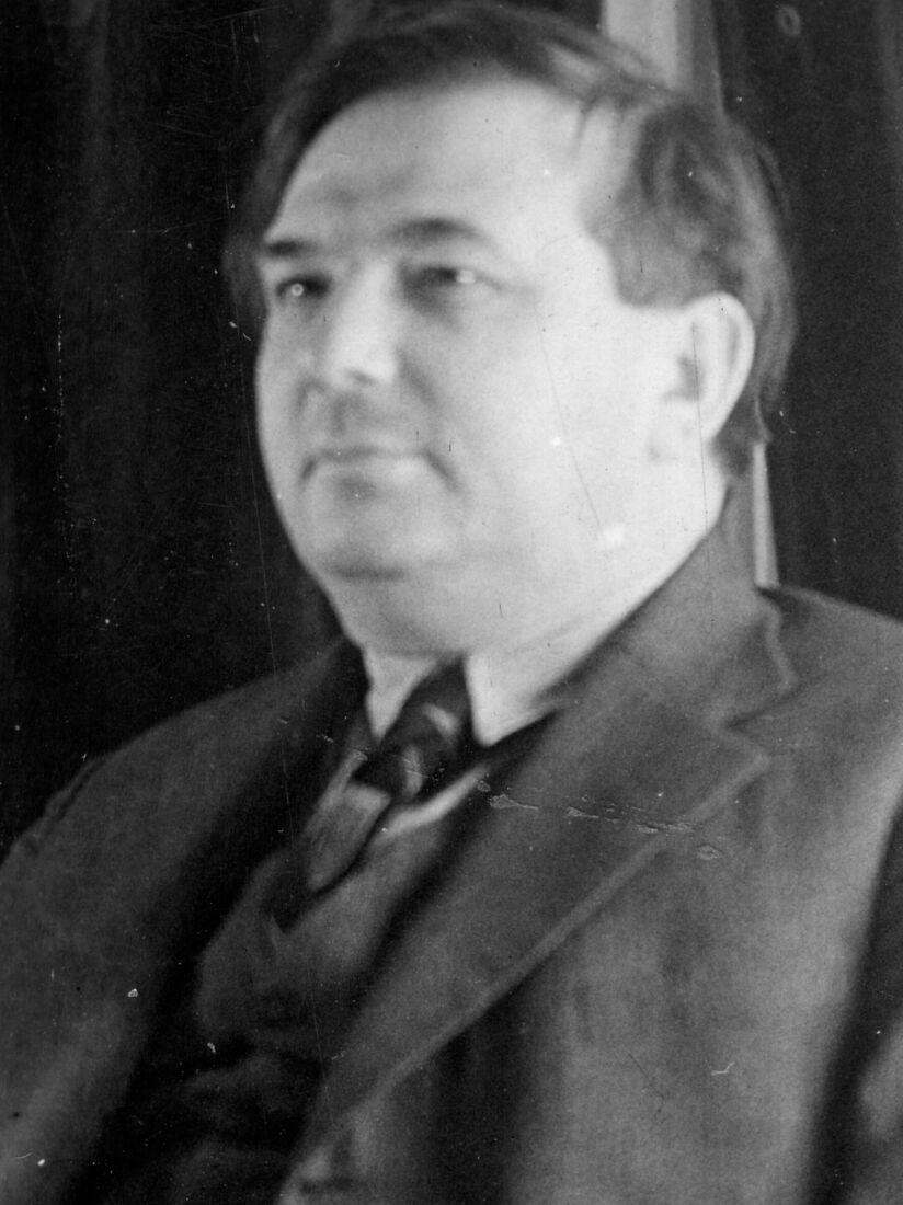 Schwarzweiß Fotografie. Porträt von Imre Bródy, bis zur Brust sichtbar, stämmig, im Anzug, Blick nach links vorne. 