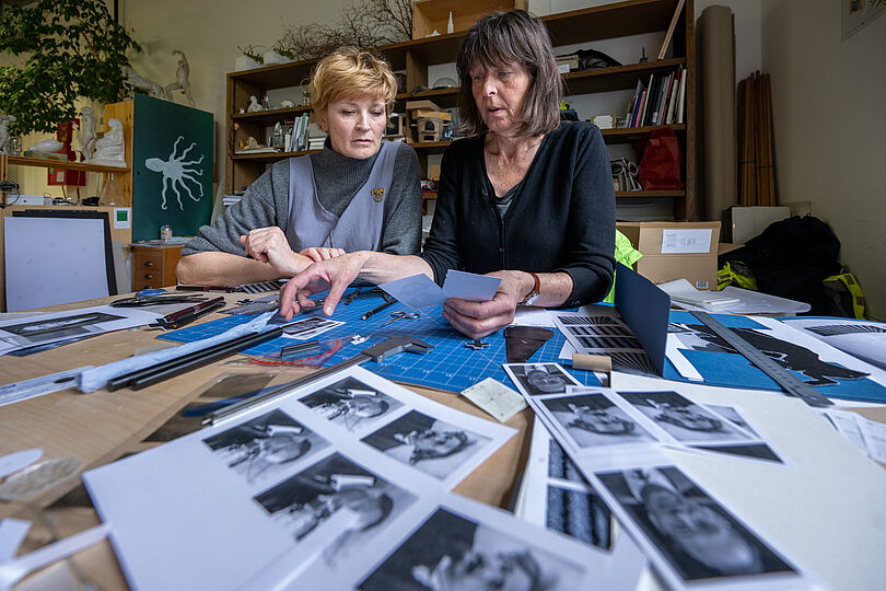 Elisabeth Straßer und Sabine Köhl sitzen an einem Tisch mit vielen Skizzen und Blätern.